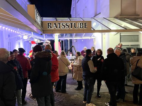 Das Bild zeigt mehrere Personen freudig zusammenstehend.