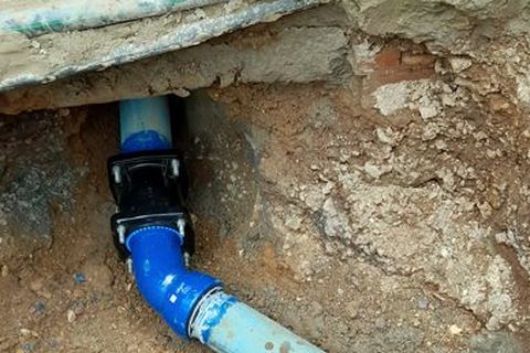 Freigelegte Wasserleitung in einer Baugrube