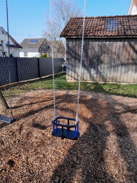 Das Bild zeigt eine blaue Kleinkindschaukel.