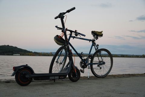 Fahrrad und E-Roller vor einem See